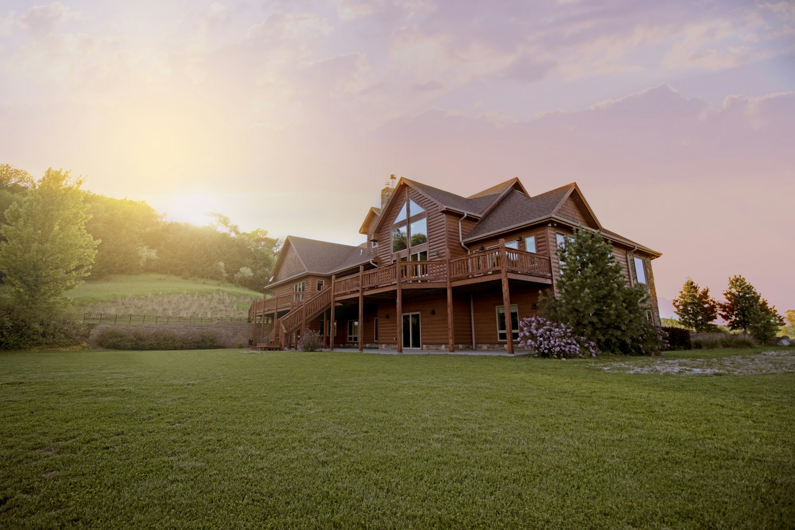 An inviting home surrounded by trees and a sunlit lawn